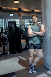 a man leaning against a wall in a gym